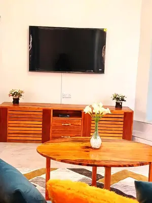a living room with a coffee table and a tv at Safi House in Boma la Ngombe