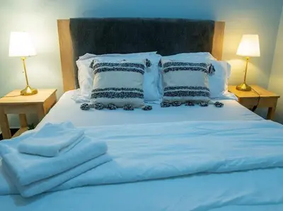 a blue bed with white sheets and pillows at ILBORU HAVEN HOMEs in Arusha