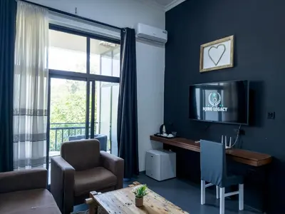 a living room with a couch and a table and a tv at The New Njiro Legacy in Arusha