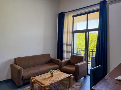 a living room with a couch and a table and a window at The New Njiro Legacy in Arusha