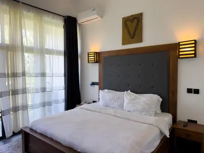 a bedroom with a large bed and a window at The New Njiro Legacy in Arusha