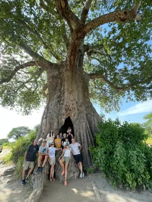 a group of people posing in front of a tree at The New Njiro Legacy in Arusha