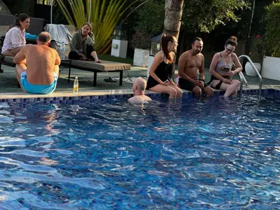 a group of people sitting around a swimming pool at The New Njiro Legacy in Arusha