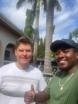 a man giving a thumbs up next to another man at Kilimanjaro Trekcity Hostel in Moshi