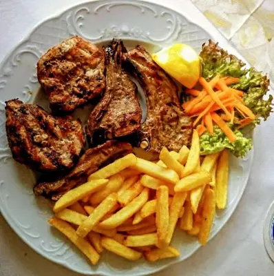 a plate of food with meat and french fries at Destination 3Degrees Hotel in Arusha