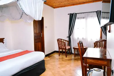 a bedroom with a bed and a desk and a window at Destination 3Degrees Hotel in Arusha