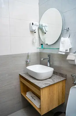 a bathroom with a sink and a mirror at Primeland Hotel in Moshi