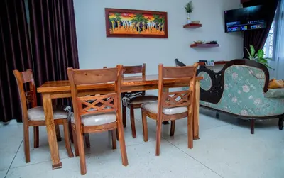 a dining room table with chairs and a couch at B&B HOTEL in Moshi