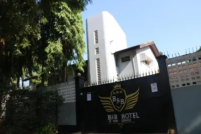 a gate to the big hotel with a building in the background at B&B HOTEL in Moshi