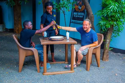 a group of three men sitting around a table at B&B HOTEL in Moshi