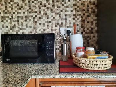 a kitchen counter with a microwave and a basket at Ellyz Home Stay in Moshi