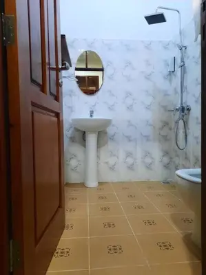 a white bathroom with a sink and a toilet at Ellyz Home Stay in Moshi