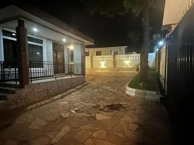 a night view of a house with a stone driveway at Ellyz Home Stay in Moshi