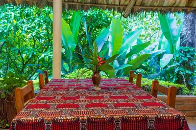 a table with a vase sitting on top of it at Meru Mbega Lodge in Usa River