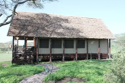 a small building with a thatched roof at Lake Ndutu Luxury Tented Lodge in Sinoni