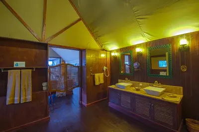a large bathroom with two sinks and a mirror at Lake Ndutu Luxury Tented Lodge in Sinoni