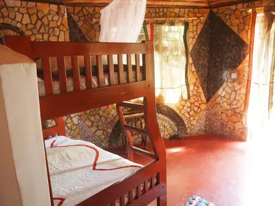 a bunk bed in a room with a wall at Songota Falls Lodge in Arusha
