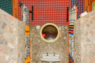 a bathroom with a sink and a mirror at Songota Falls Lodge in Arusha