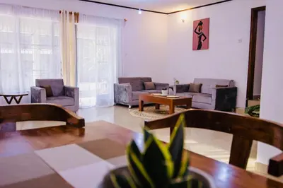 a living room with couches and a table at venem house in Kisongo