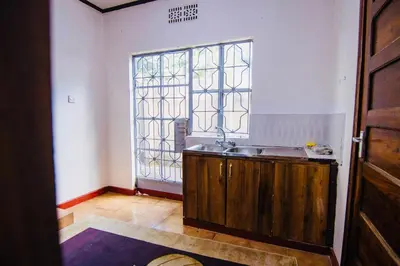a kitchen with a sink and a window at venem house in Kisongo