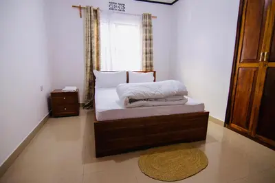 a small bed in a room with a window at venem house in Kisongo
