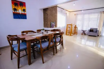 a dining room with a wooden table and chairs at venem house in Kisongo