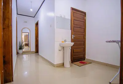 a bathroom with a sink and a wooden door at venem house in Kisongo