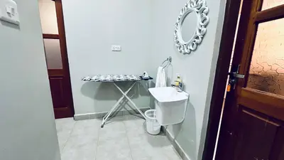a bathroom with a sink and a table with a mirror at Mvule Homes in Arusha