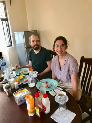 a man and a woman sitting at a table with food at Msovi Hideaway in Arusha