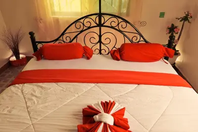 a bed with red pillows and a red bow on it at Msovi Hideaway in Arusha
