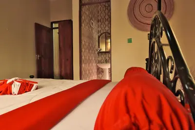 a bed with a red blanket on top of it at Msovi Hideaway in Arusha