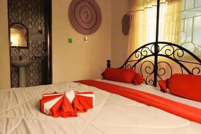 a bedroom with two beds with red and white sheets at Msovi Hideaway in Arusha