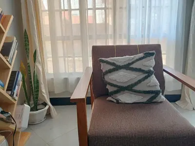 a chair with a pillow on it with a window at Sinana Escapes - Arusha in Arusha