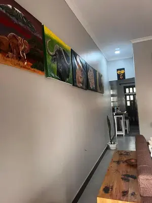a living room with paintings on the wall at Sinana Escapes - Arusha in Arusha