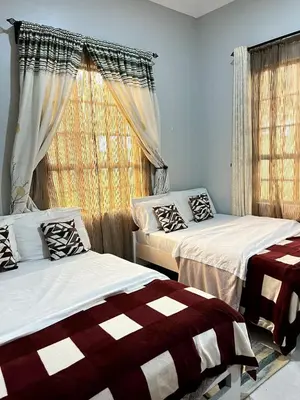 a bedroom with two beds and a window at Sinana Escapes - Arusha in Arusha