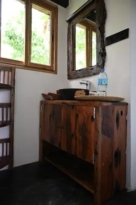 a bathroom with a wooden sink and a mirror at Msitu Hut in Tuvaila