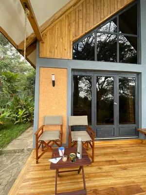 a patio with two chairs and a table at Msitu Hut in Tuvaila