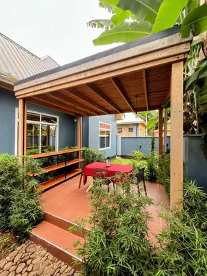 a covered patio with a red table and benches at Moshi Epic Accommodation in Moshi