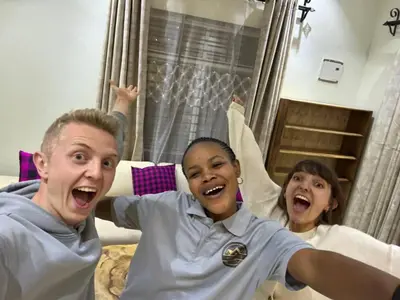 two people laying on a bed with their hands in the air at Moshi Epic Accommodation in Moshi