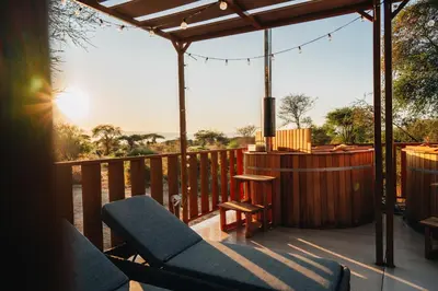 a wooden deck with a couch and a table on it at Elephant lodge in Kwa Kuchinia