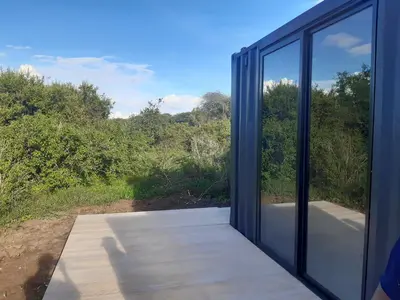 an open glass door with a view of a forest at Elephant lodge in Kwa Kuchinia