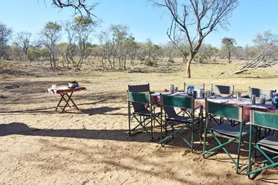 a group of tables and chairs in the desert at Elephant lodge in Kwa Kuchinia