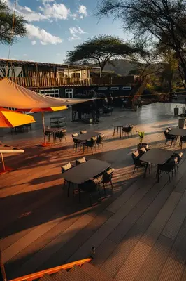 a group of tables and chairs on a deck at Elephant lodge in Kwa Kuchinia