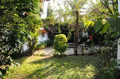 a garden with a table and chairs in the yard at OYA Guest House in Usa River
