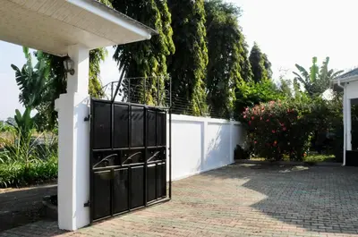 a gate to a house with a white fence at OYA Guest House in Usa River