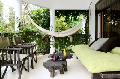 a living room with a couch and a hammock at OYA Guest House in Usa River