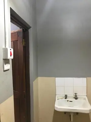a bathroom with a white sink and a mirror at Janibichi Adventures hostel in Moshi