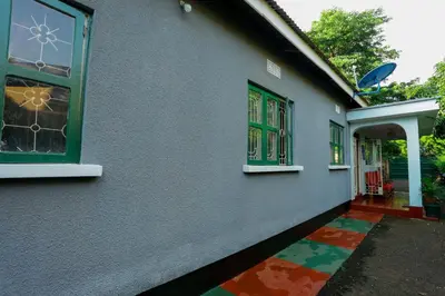 a house with green windows and a colorful floor at Janibichi Adventures hostel in Moshi