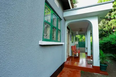 an entrance to a house with green windows at Janibichi Adventures hostel in Moshi