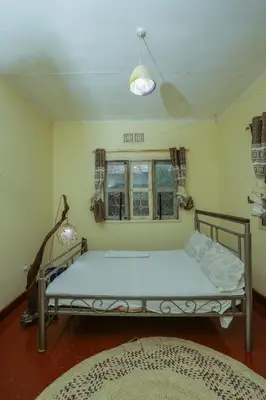a bedroom with a bed and a window at Janibichi Adventures hostel in Moshi